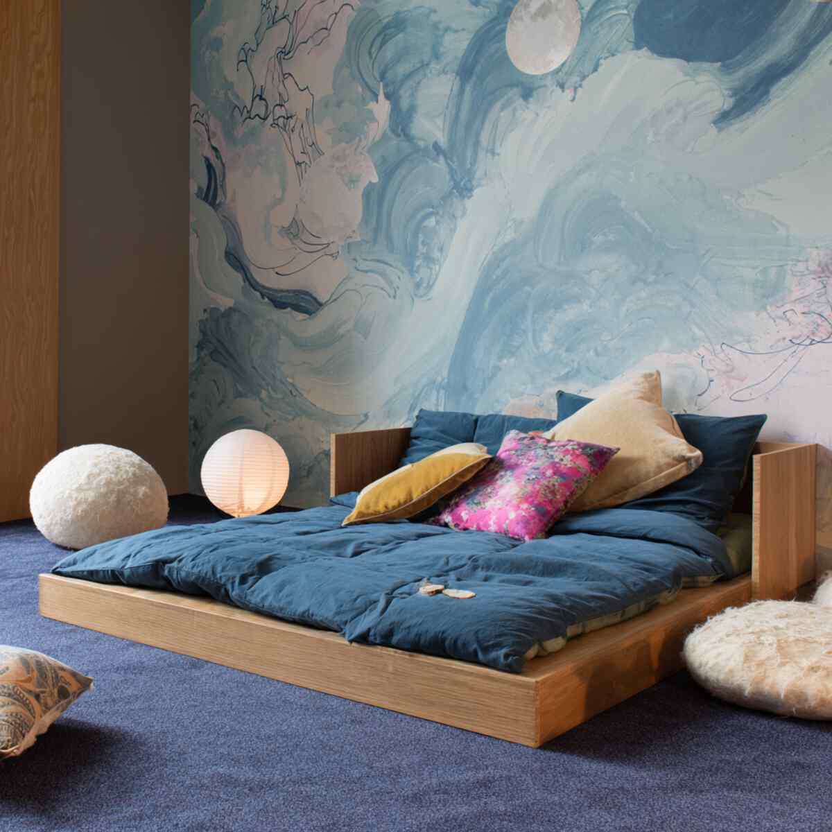 Floor Bed with Art-Covered Wall Backdrop
